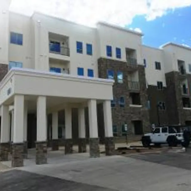 Exterior view of a new apartment complex with a stone entrance and multiple stories.
