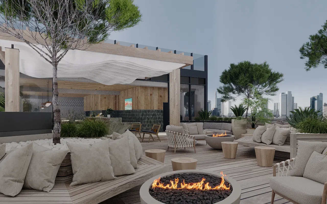 A modern rooftop lounge area with comfortable seating, fire pit, and greenery in an urban setting.