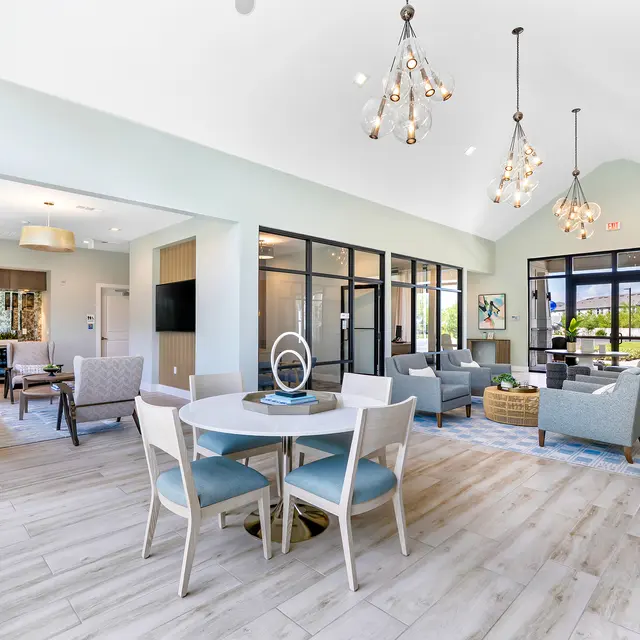 Modern Common Area A bright and airy modern living area featuring a seating arrangement, dining table, and large windows letting in natural light.