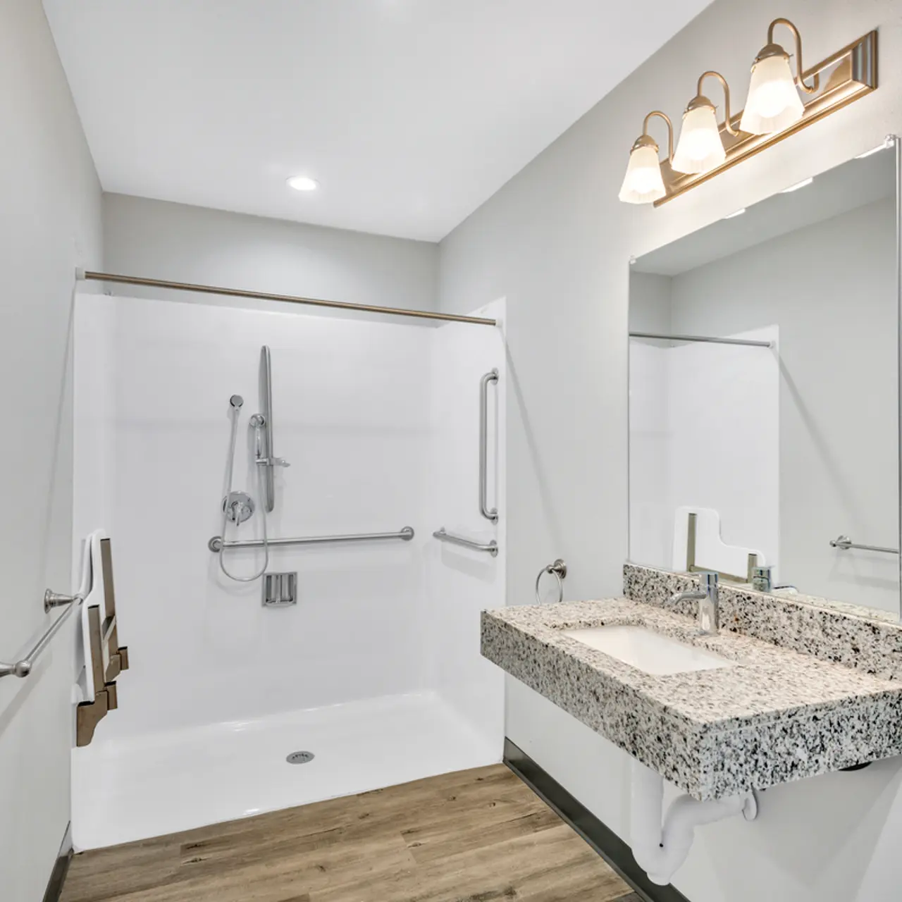 A spacious modern bathroom featuring a walk-in shower, granite sink, and minimalist design elements.