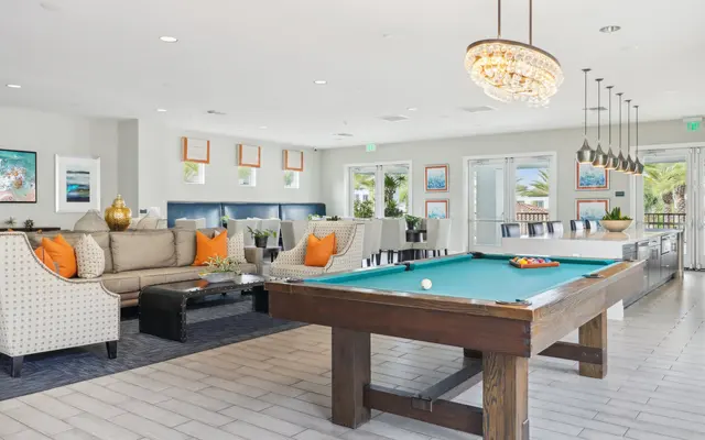 A spacious lounge area featuring a billiards table and comfortable seating.