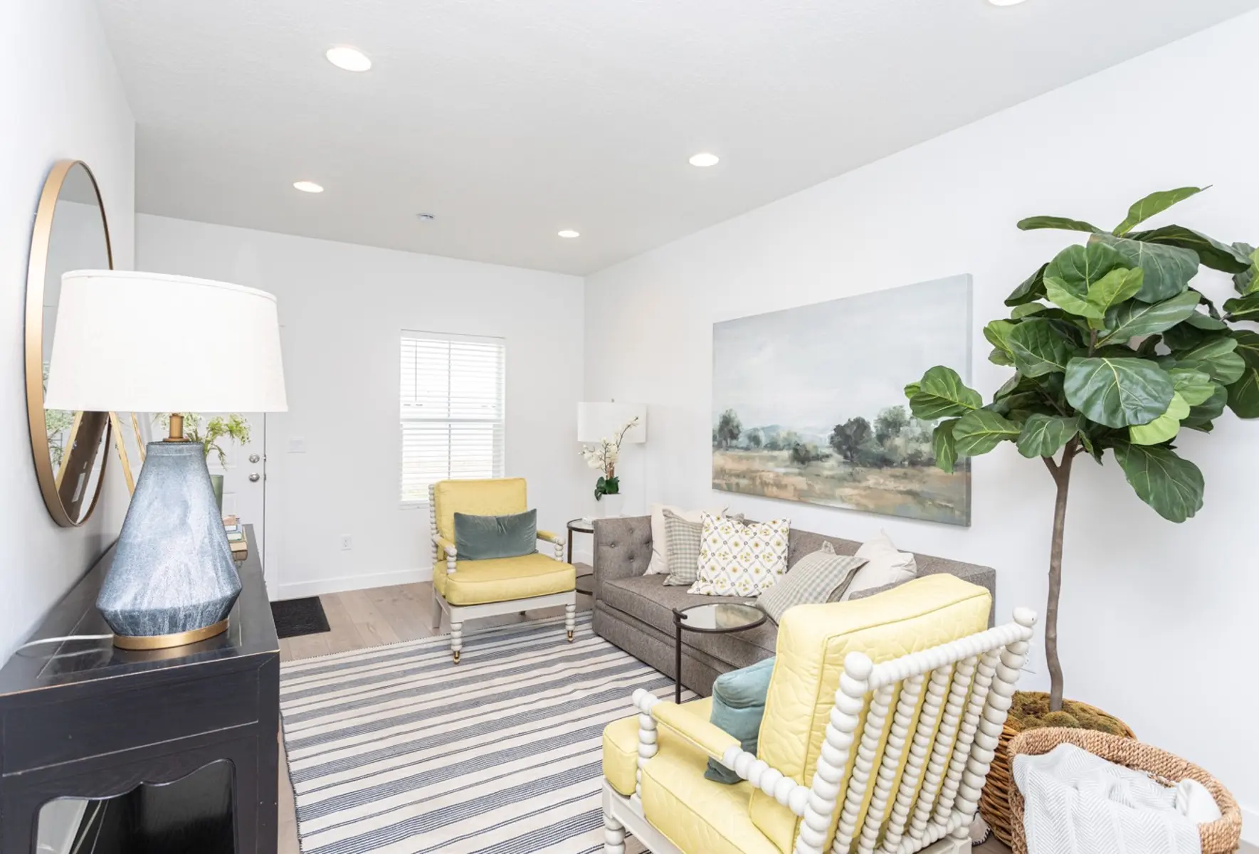 Chic Modern Living Room A bright and welcoming living room featuring a yellow accent chair, a gray sofa, and a large painting on the wall. There are potted plants and decorative elements, with soft lighting from recessed lights.