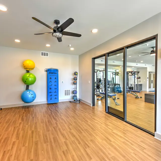 Modern Fitness Room Interior Interior of a modern fitness room with hardwood flooring and mirrors reflecting gym equipment.