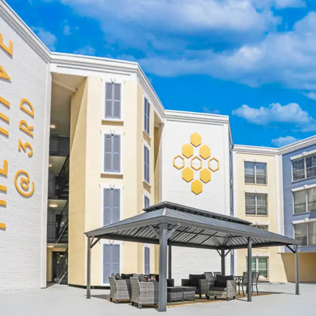Exterior view of The Hive @ 3rd, featuring modern architecture with a covered seating area.