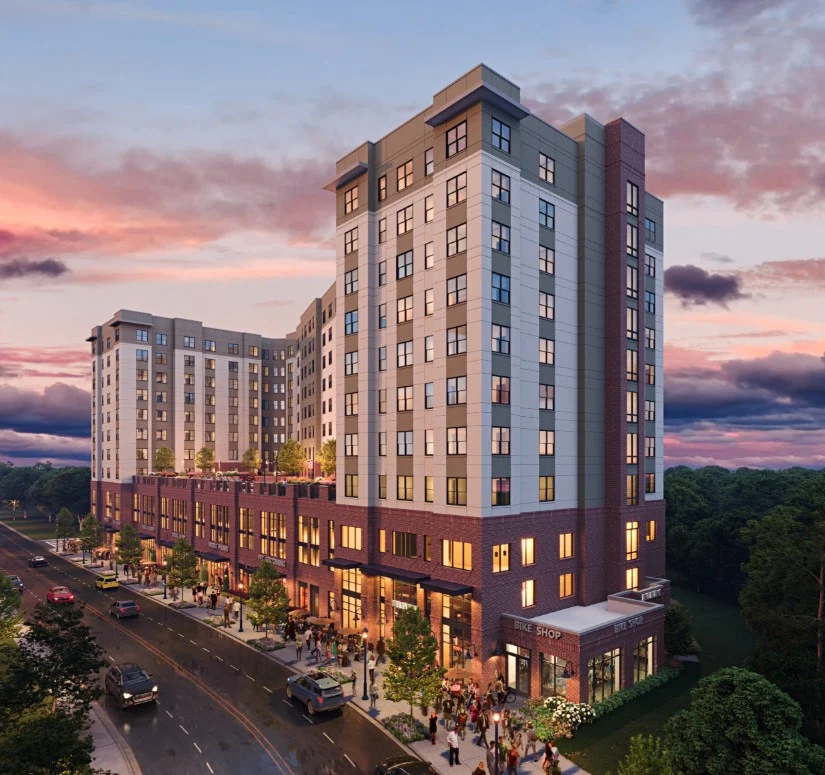 Modern Apartment Complex at Sunset A modern multi-story apartment building with a mixed-use ground floor, situated along a street at sunset. The building features large windows and a rooftop terrace, with people gathered outside.