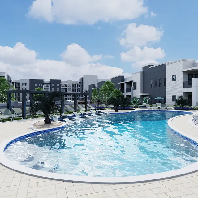 A modern pool area with a curved pool surrounded by lounge chairs, palm trees, and contemporary buildings in the background under a blue sky with clouds.