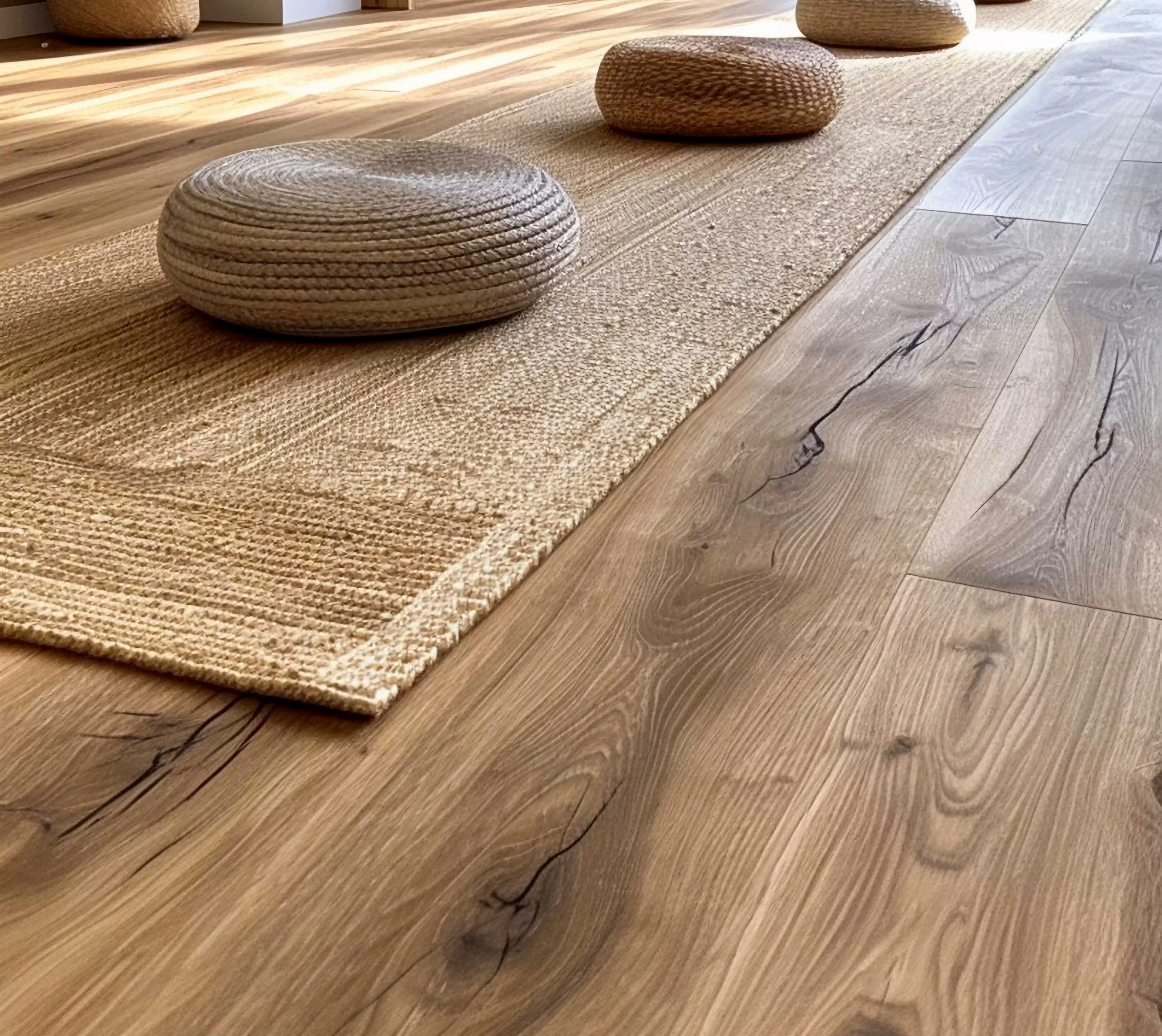 A modern and cozy interior living space featuring a woven rug on wooden flooring and round cushions.