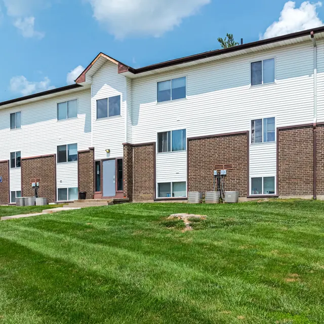Apartment Building Exterior Exterior view of a two-story apartment building with a green lawn in front.
