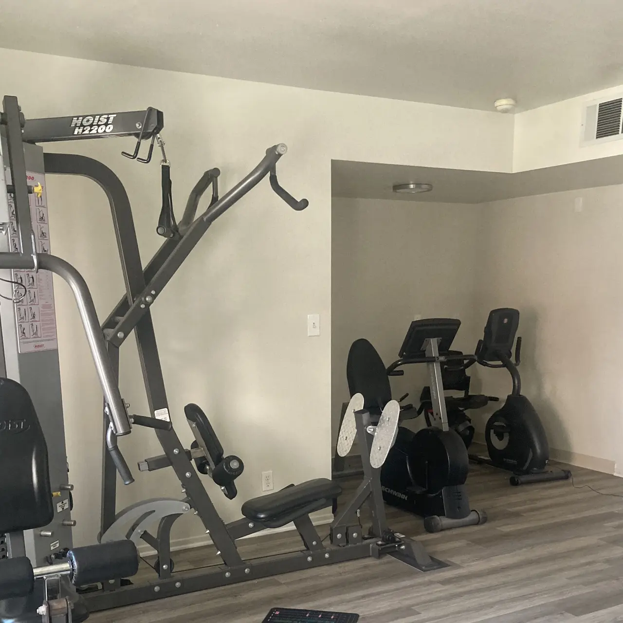 A home gym featuring a multi-station weight machine and an exercise bike.