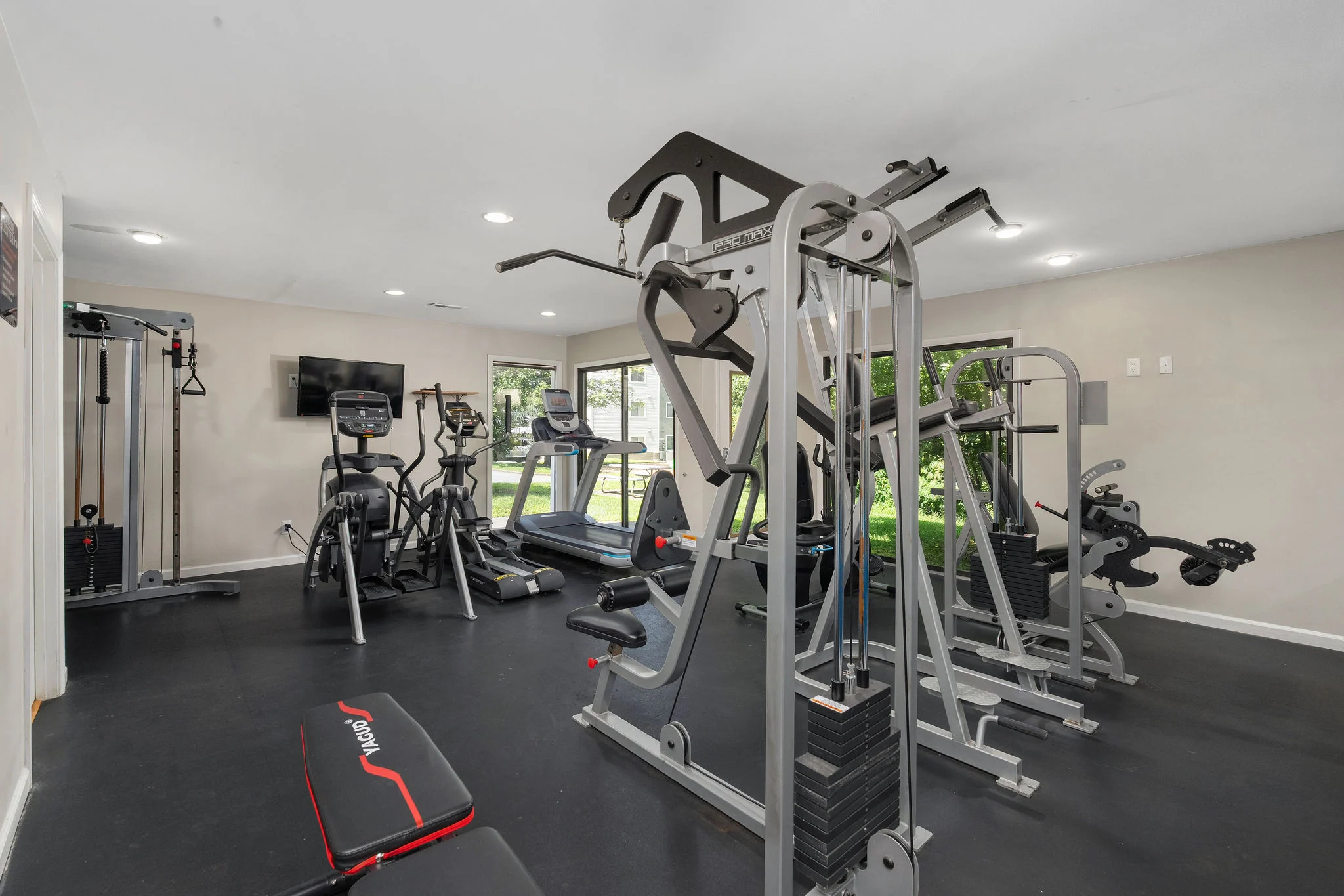 A well-equipped gym room featuring various workout machines and exercise equipment.