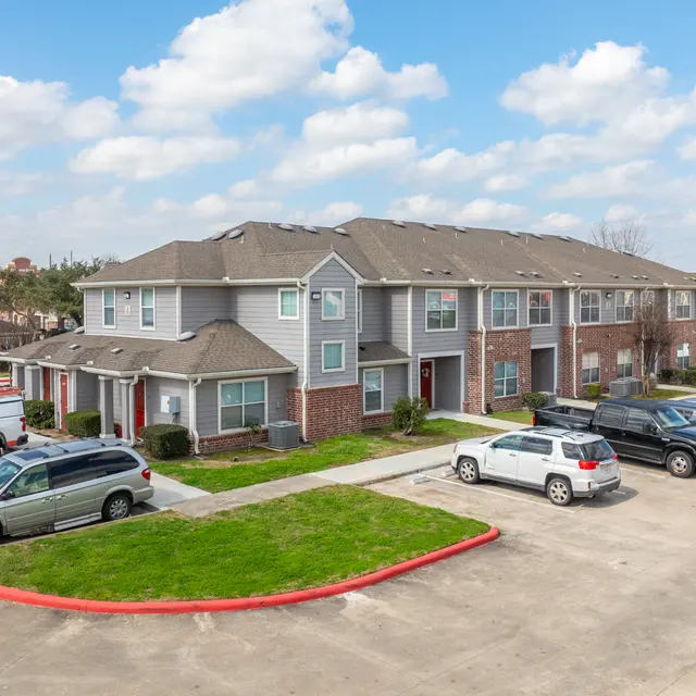 Aerial view of a well-maintained apartment complex with multiple units and a parking lot.