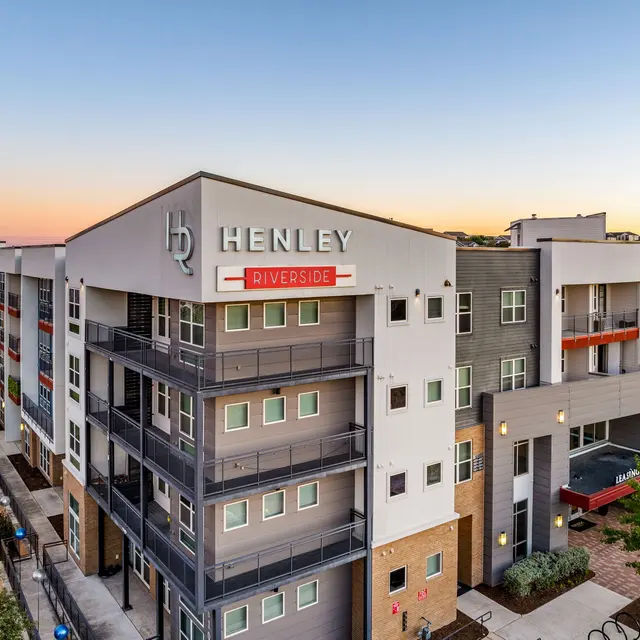 Exterior view of Henley Riverside apartments during sunset.