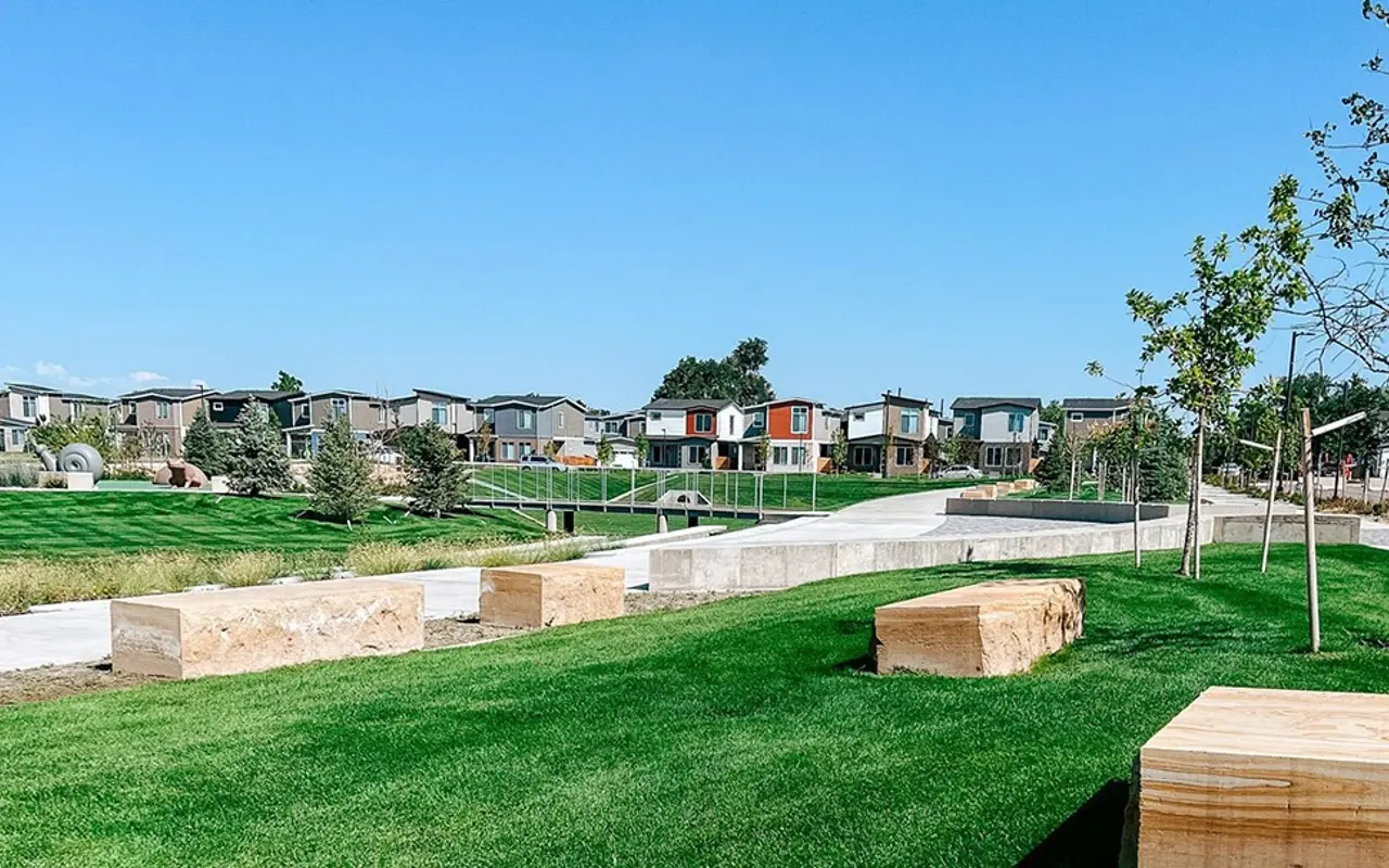 View of a modern residential community with green lawns and wooden benches.
