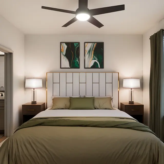 A modern bedroom featuring a large bed with a green comforter, two bedside tables with lamps, and abstract wall art. The room includes a window with curtains and a view of green spaces outside.