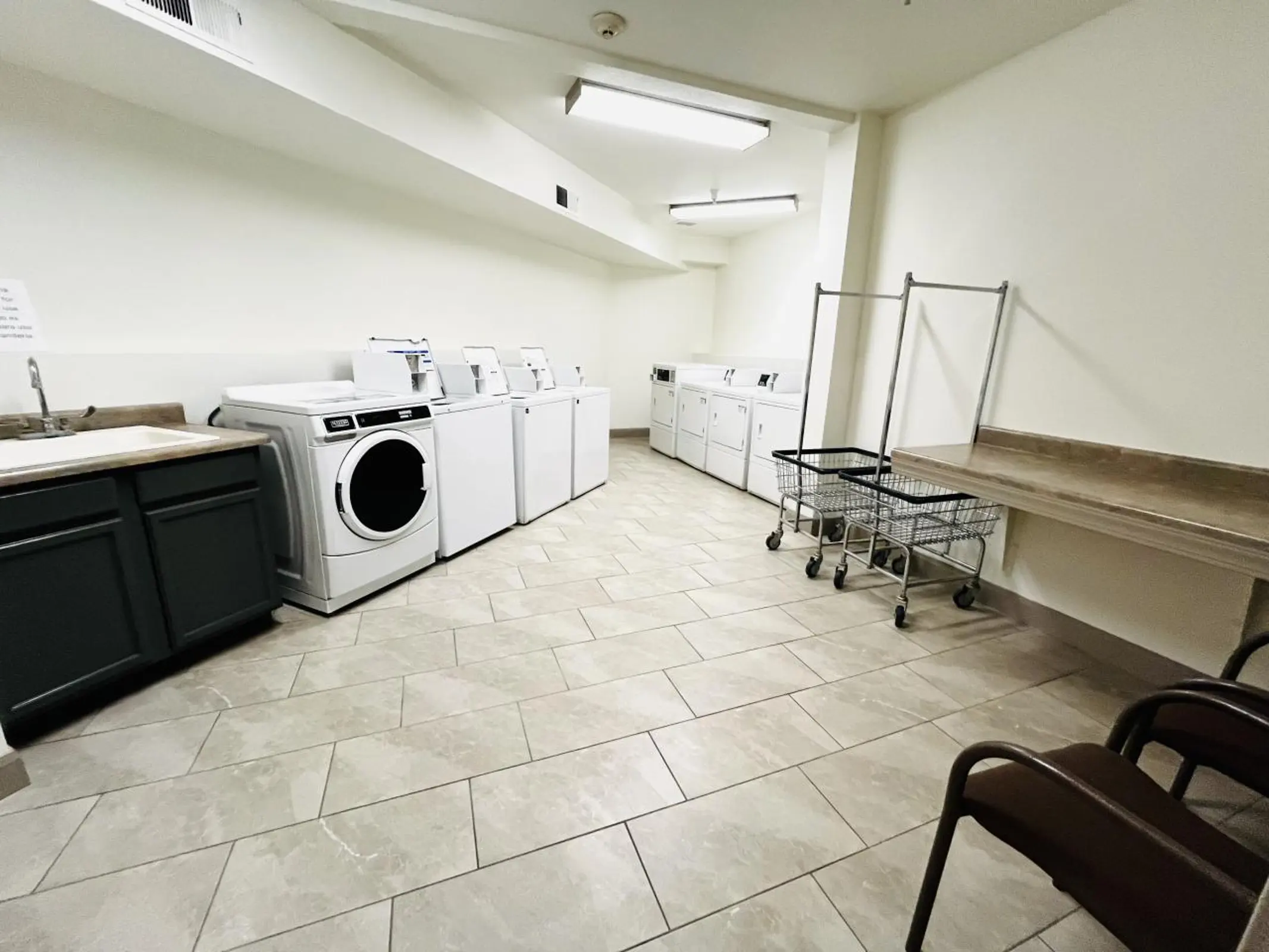 Laundry room with washers,dryers,folding counter and laundry carts.