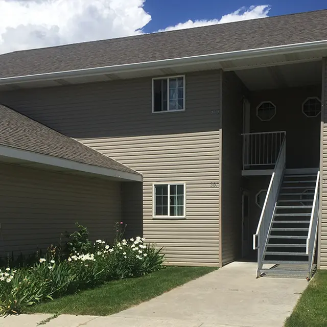 Apartment Building Exterior Exterior view of an apartment building with a staircase and manicured landscaping.