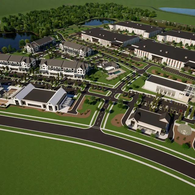 Aerial view of a new residential and commercial development featuring multiple buildings, green spaces, and a pond.