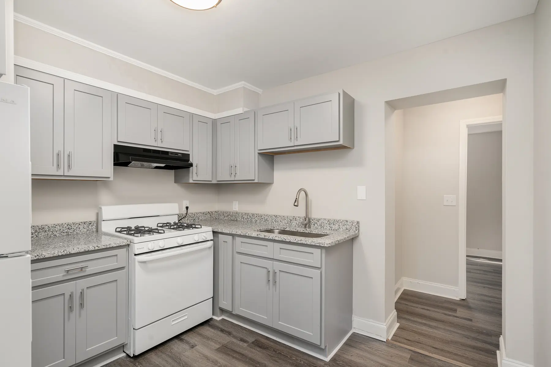 Interior view of a modern kitchen with gray cabinets and a white gas stove.