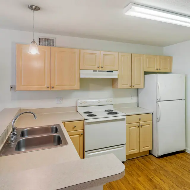 Modern kitchen with beige cabinetry and white appliances