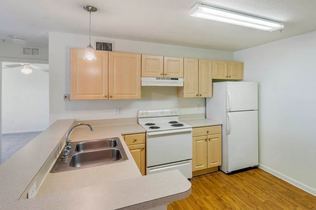 Modern kitchen with beige cabinetry and white appliances