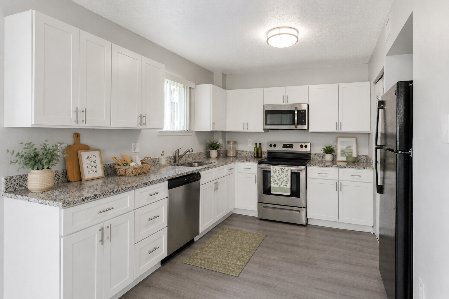 Modern Kitchen Design A modern kitchen featuring white cabinetry, stainless steel appliances, and a granite countertop with decorative items.