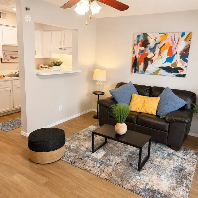 Cozy living room with a brown sofa, colorful wall art, and modern decor.