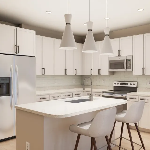 A modern kitchen featuring white cabinetry, stainless steel appliances, and a central island with seating. Pendant lights hang above the island, adding a contemporary touch.