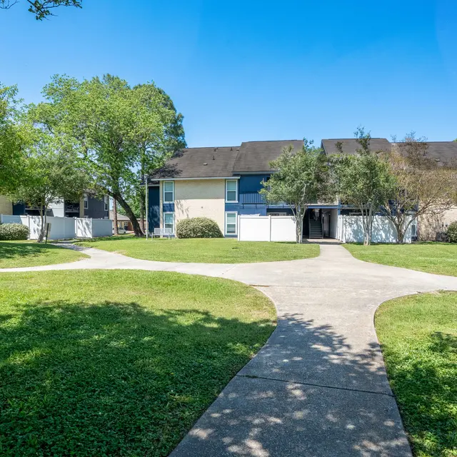 View of an apartment complex surrounded by greenery and pathways.