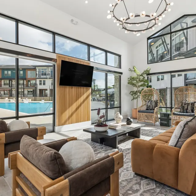 Stylish Community Lounge Area A modern community lounge area featuring large windows overlooking a swimming pool, stylish seating arrangements, and decorative plants.