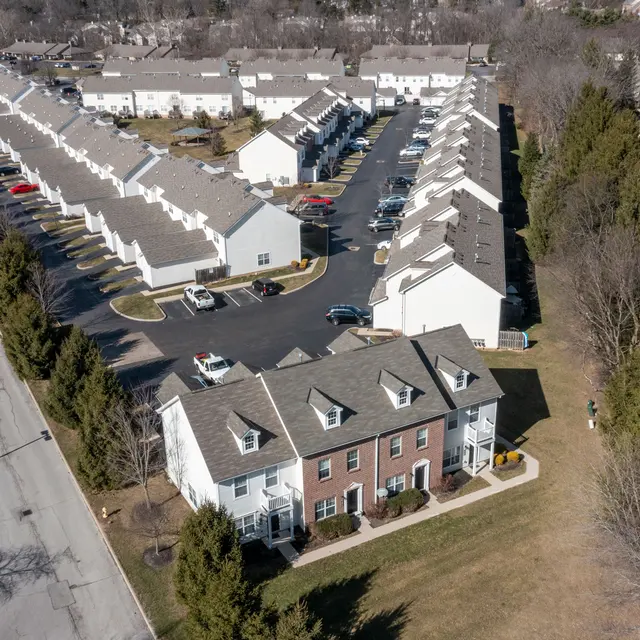Aerial view of a residential apartment complex with multiple buildings and parking lots.