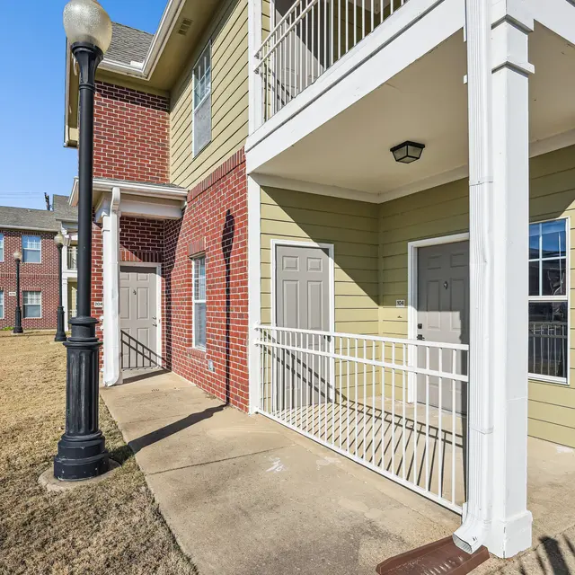 Apartment Building Exterior Exterior view of an apartment building featuring two sets of doors and a lamp post in front.
