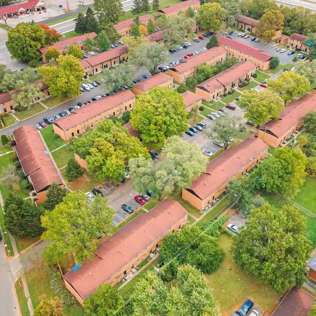 Aerial view of a residential apartment complex surrounded by greenery and trees.