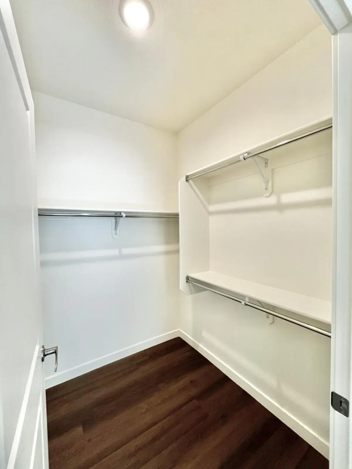 Walk-in closet with shelves and hanging rails.