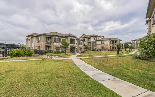 Modern Residential Complex A landscaped residential complex with multiple buildings surrounded by green grass and pathways.