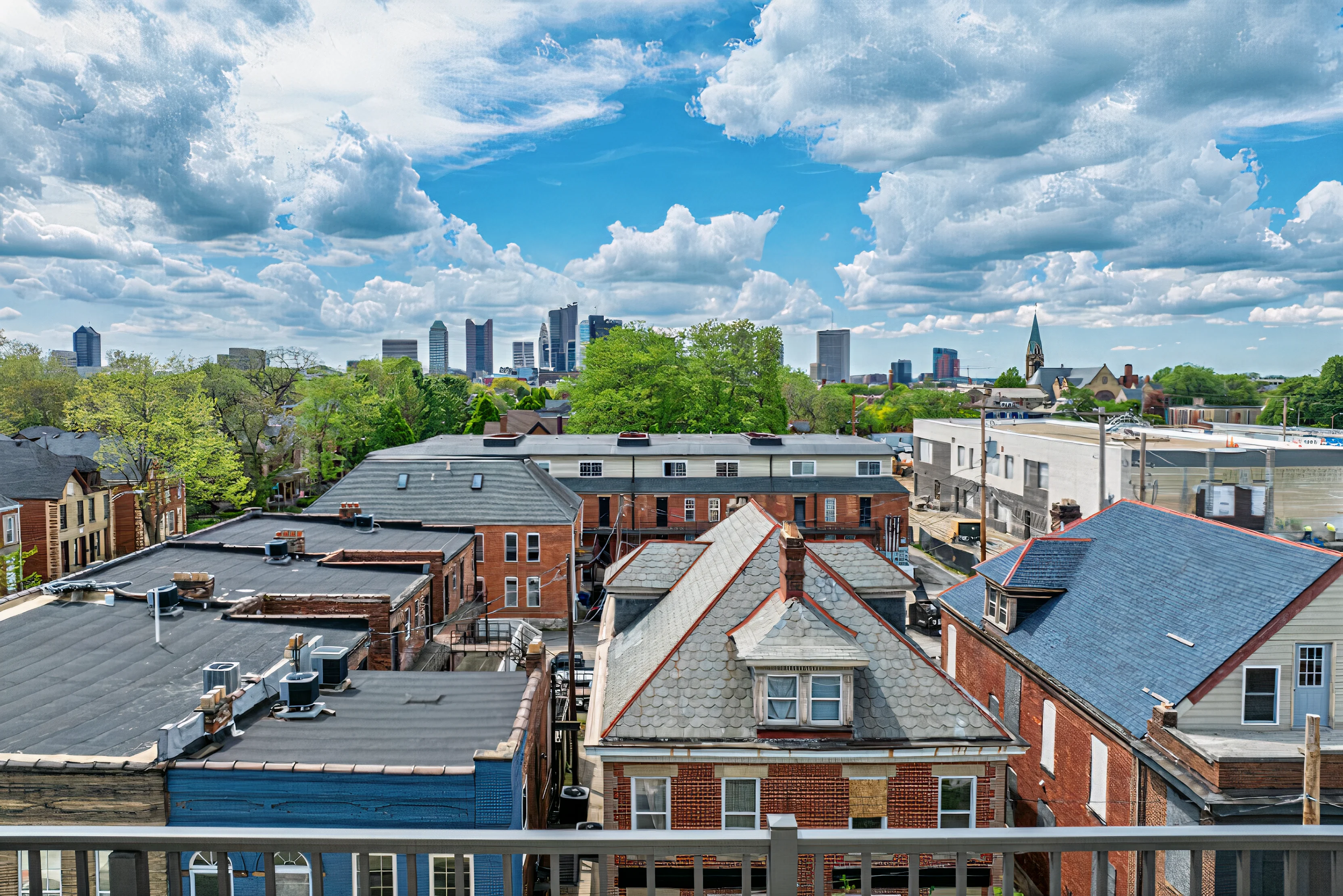 A panoramic view of a city skyline surrounded by rooftops and greenery under a cloudy sky.