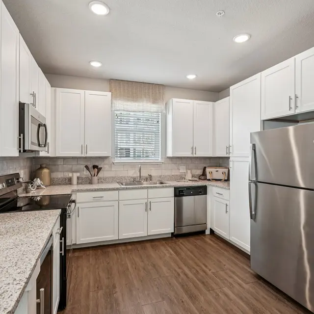 Modern Kitchen Interior A modern kitchen featuring white cabinets, stainless steel appliances, and a light-colored countertop.