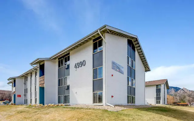 Exterior view of a modern apartment building with the number 4990.