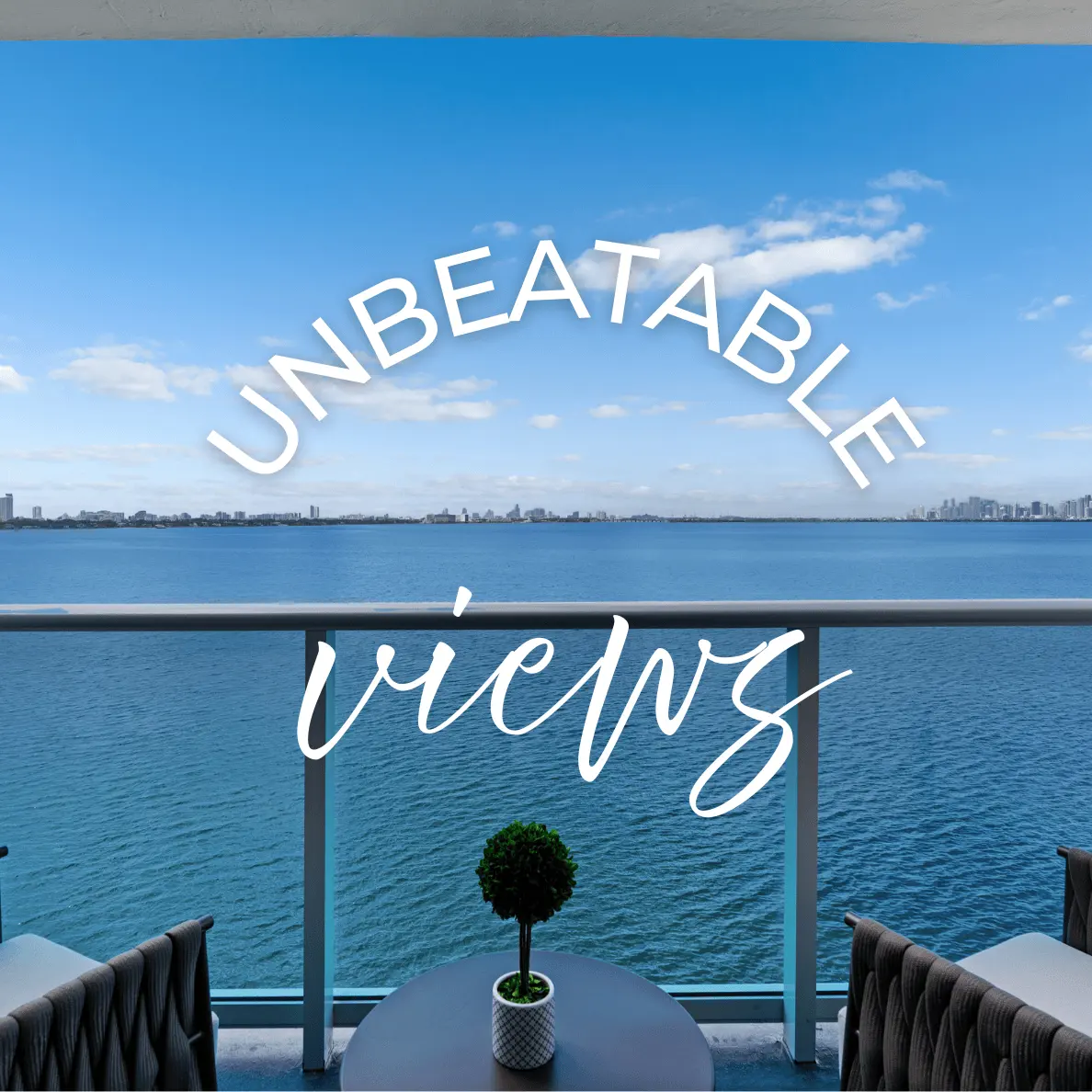 Unbeatable Views from the Balcony A balcony with stunning water views, featuring modern outdoor furniture and a small potted plant on a table.