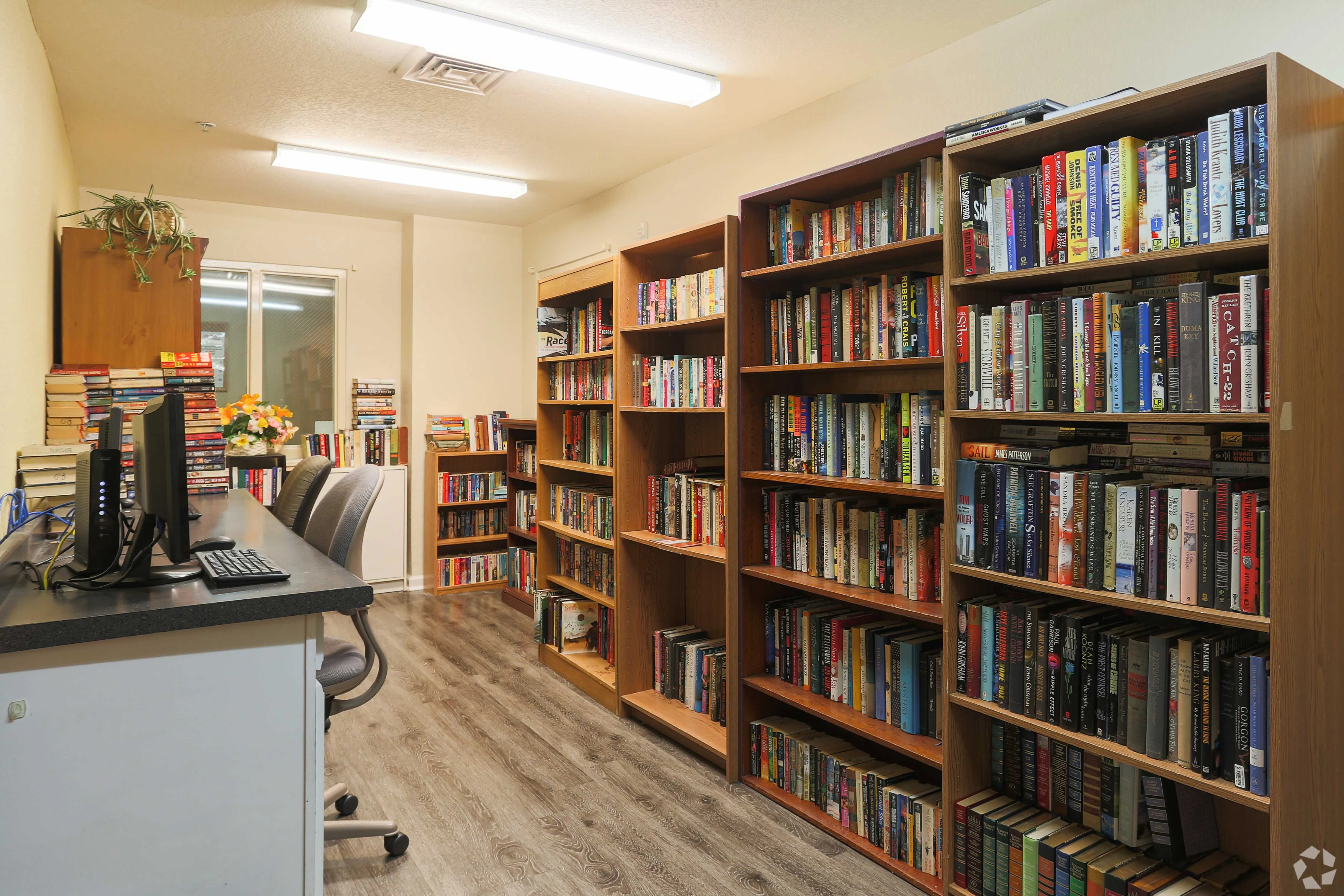 Cozy Library Interior A cozy library interior featuring wooden bookshelves filled with books and a desk with a computer.
