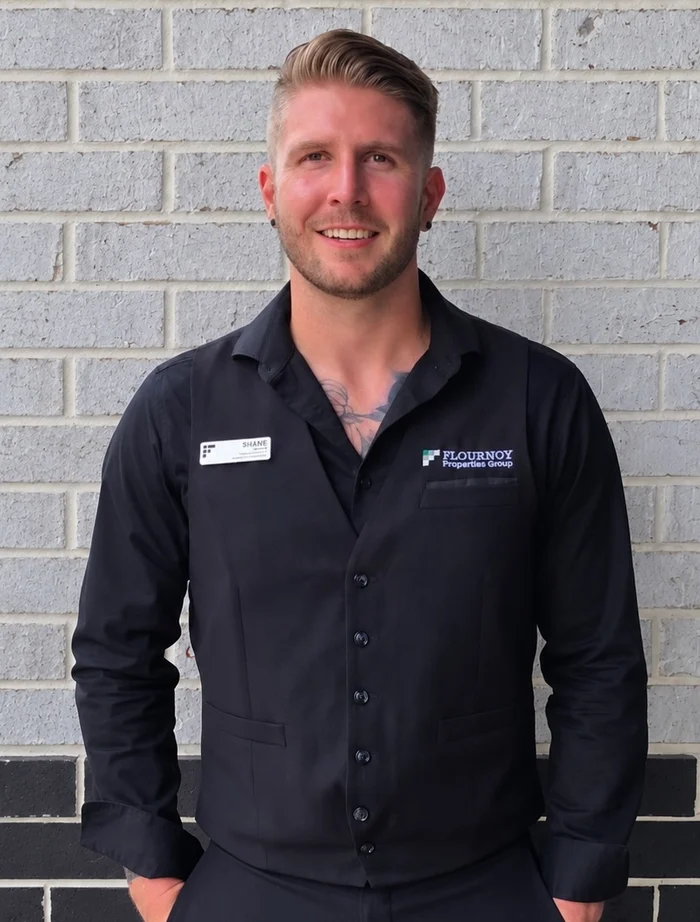 Professional Portrait Portrait of a smiling man in a black dress shirt with a name tag.