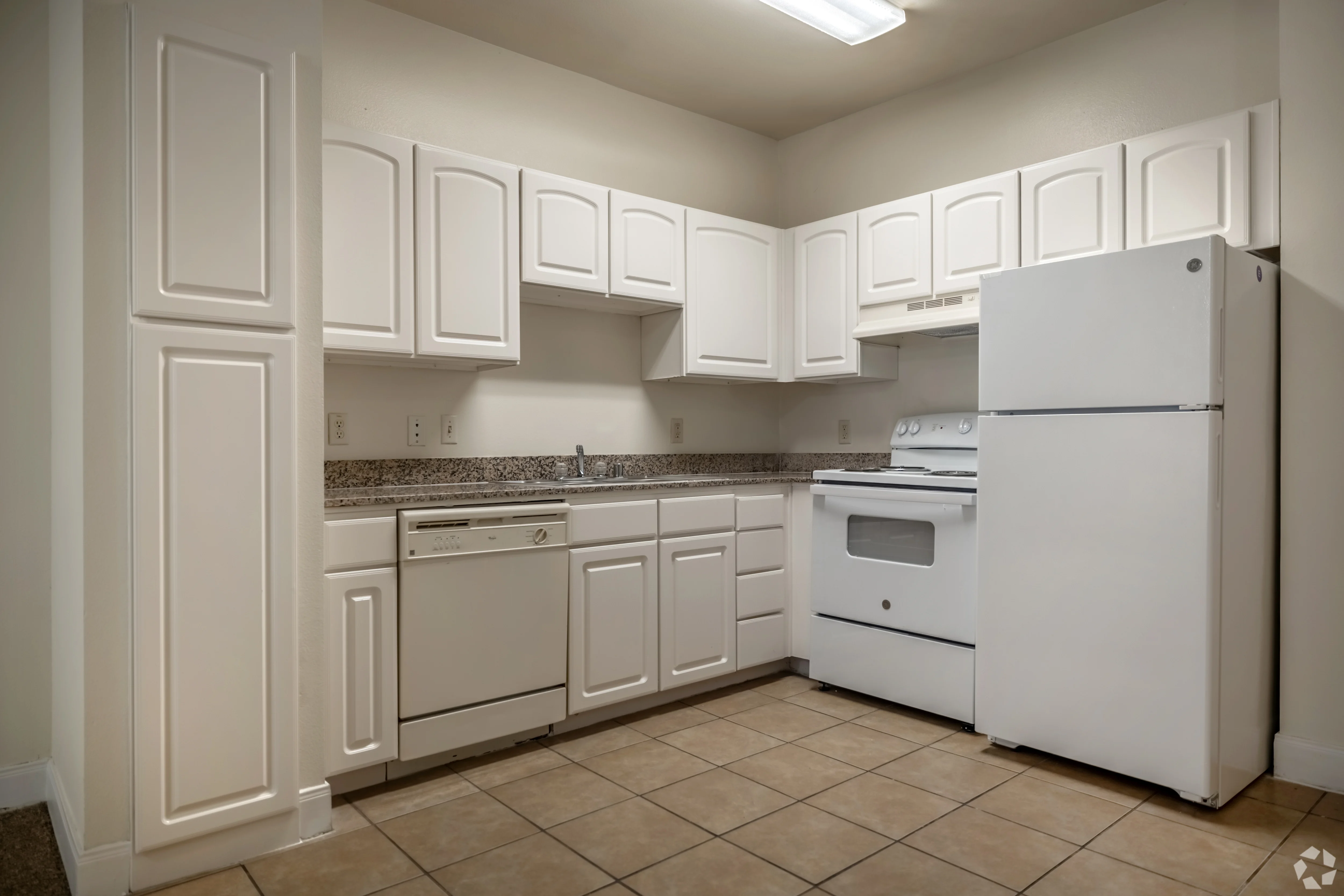 Modern Kitchen Interior A clean and modern kitchen with white cabinetry, granite countertop, and essential appliances including a refrigerator, stove, and dishwasher.