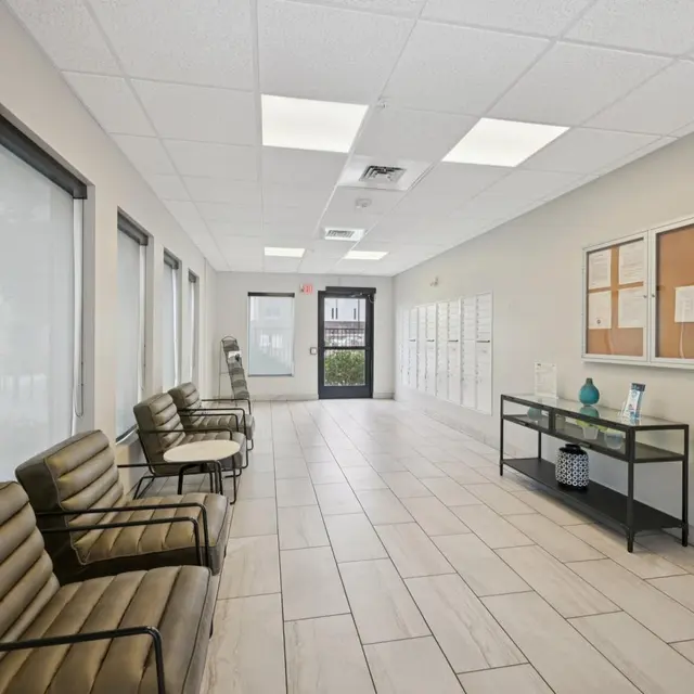 Waiting Room Interior Interior of a waiting room featuring several chairs, a decorative table, and lockers along the wall.