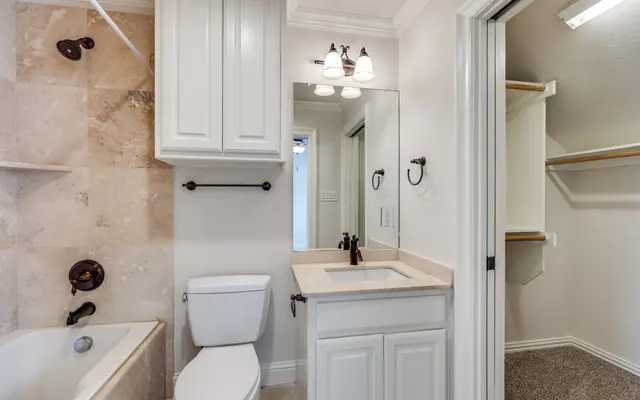 Modern Bathroom Design A well-designed modern bathroom featuring a bathtub, toilet, sink with cabinet, and closet space.