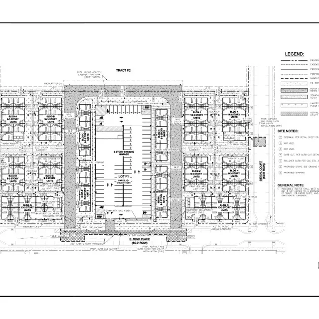 An architectural site plan for a residential development, featuring multiple housing units surrounding a central parking area.