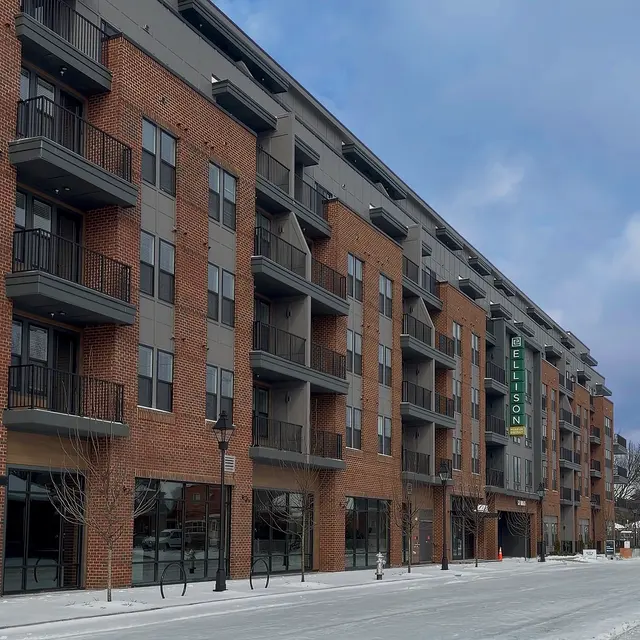 Exterior view of The Ellison apartment building featuring a brick façade and large windows with balconies.