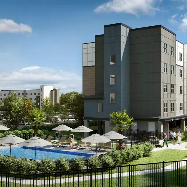 Modern Apartment Complex with Pool A modern apartment complex with a pool and landscaped grounds on a sunny day.