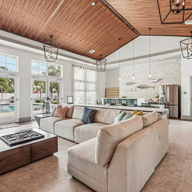 Contemporary Living Room Design Spacious modern living room with large windows and high ceiling. Features a plush sofa, coffee table, and elegant light fixtures.