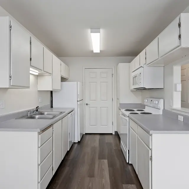 Spacious Modern Kitchen A modern kitchen with white cabinets, stainless steel appliances, and light-colored countertops.