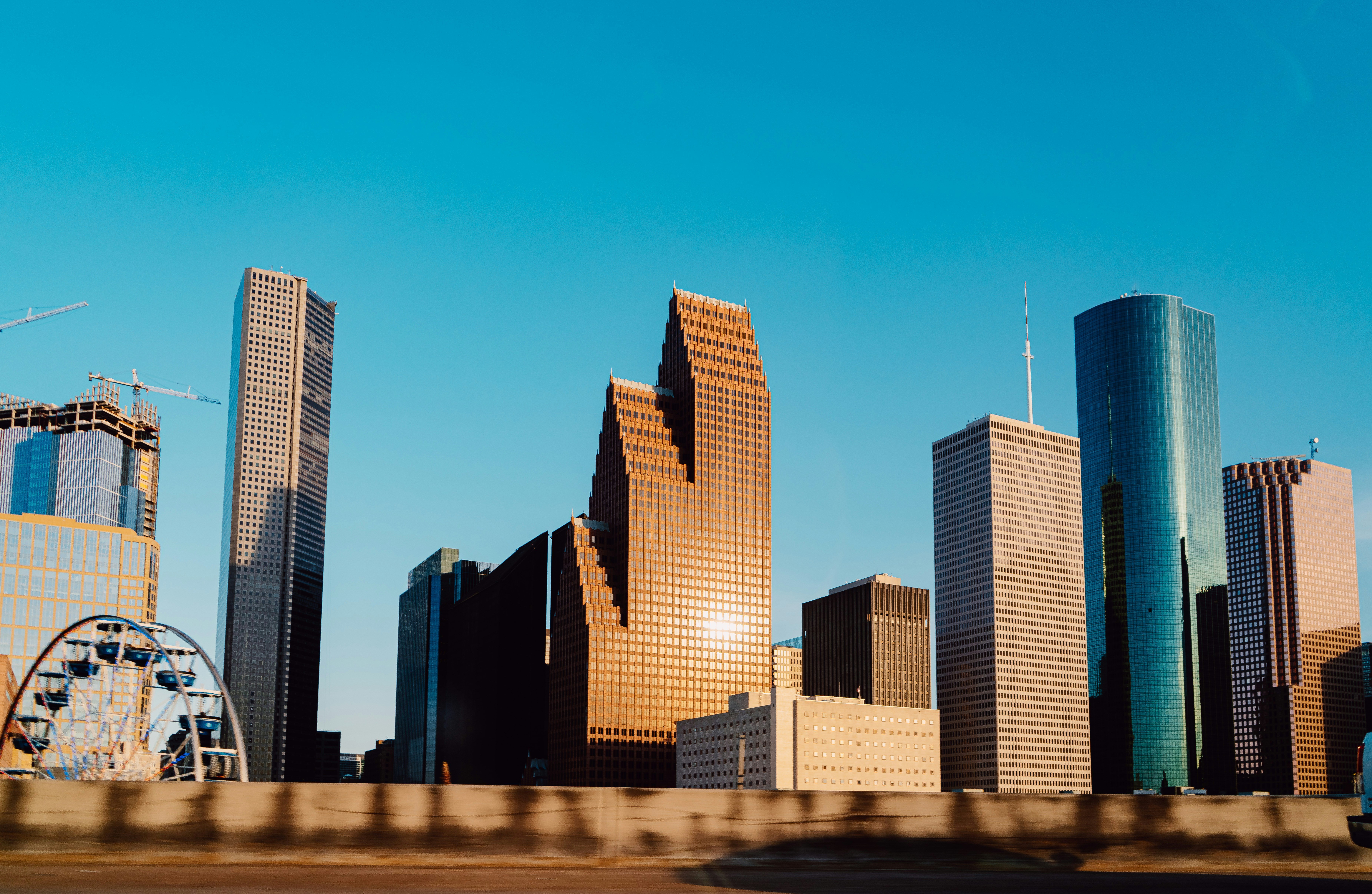 A view of the Houston skyline featuring a mix of modern skyscrapers and a ferris wheel.
