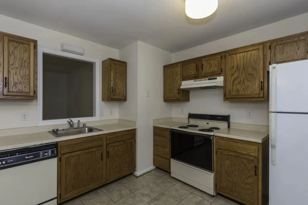 Modern Kitchen Interior A kitchen with wooden cabinets, a white countertop, and appliances including an oven and refrigerator.